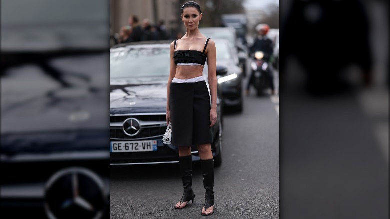 Person in black outfit and thong boots