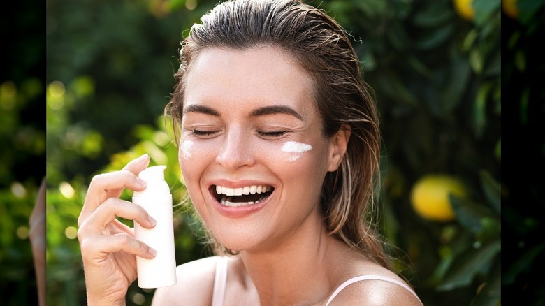 Woman applying sunscreen beneath eyes