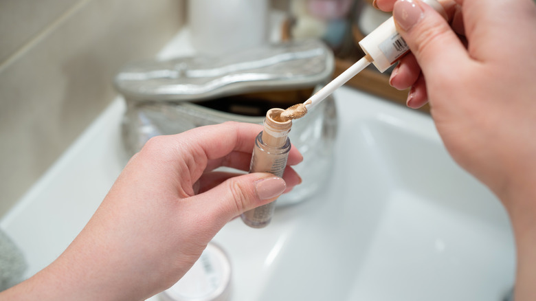 person holding concealer tube