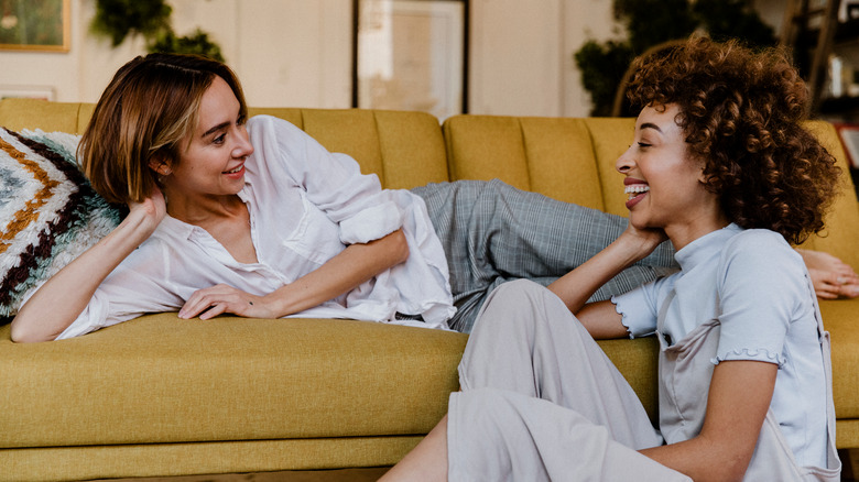 women sitting on couch talking 