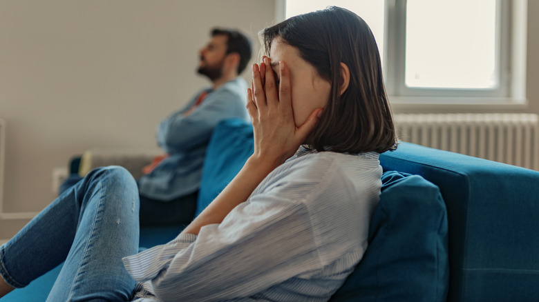 Upset couple on opposite ends of sofa