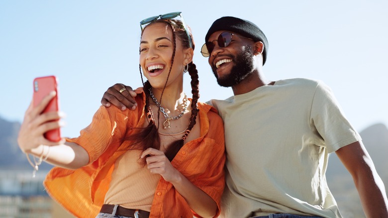 Happy couple taking selfie on rooftop