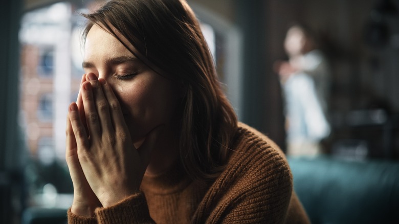 Woman sitting on couch upset