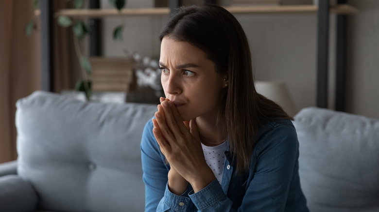 Worried woman sitting on sofa