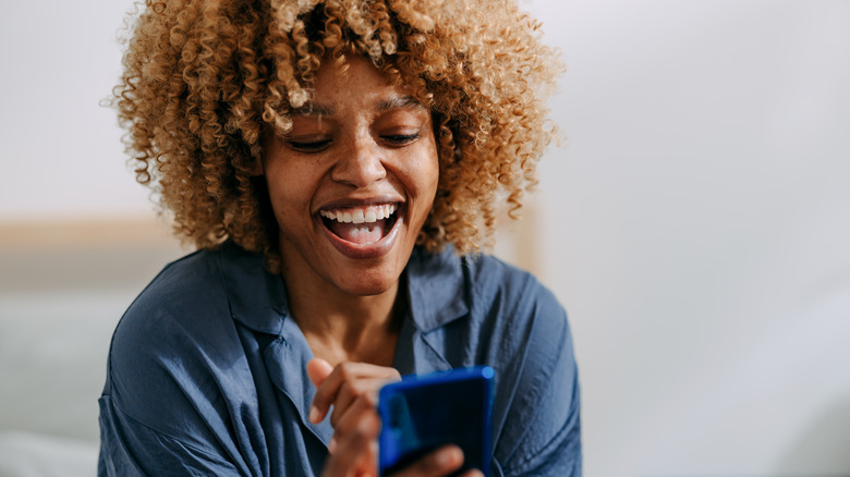 Laughing woman looking at phone