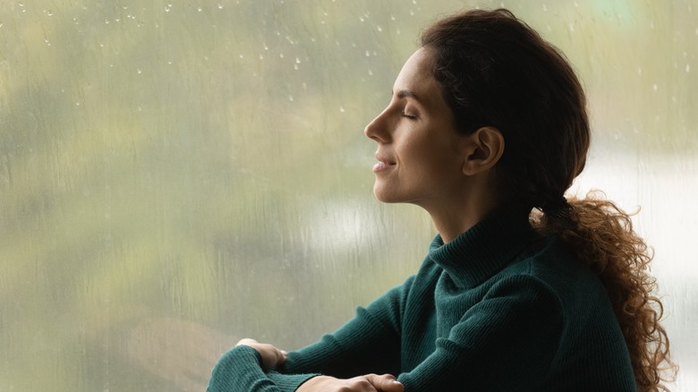 Woman thinking by rainy window