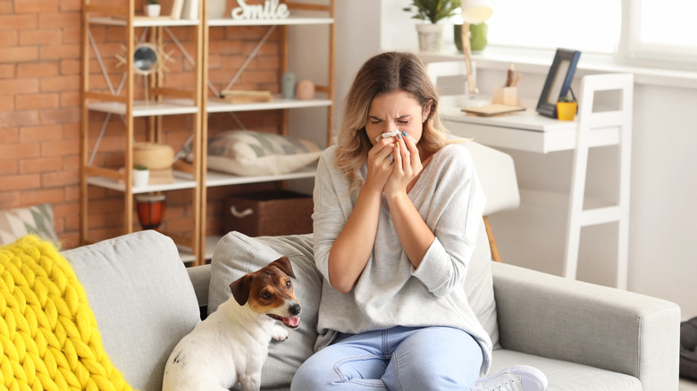 young woman blowing nose 