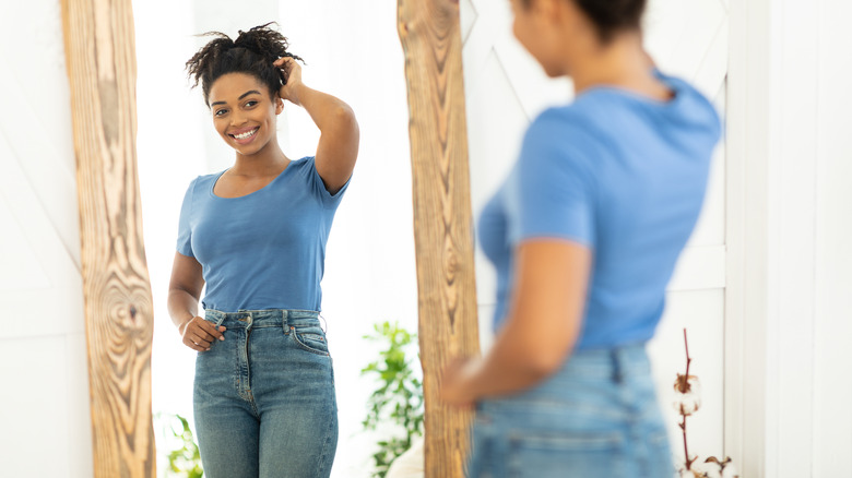 woman looking in mirror smiling