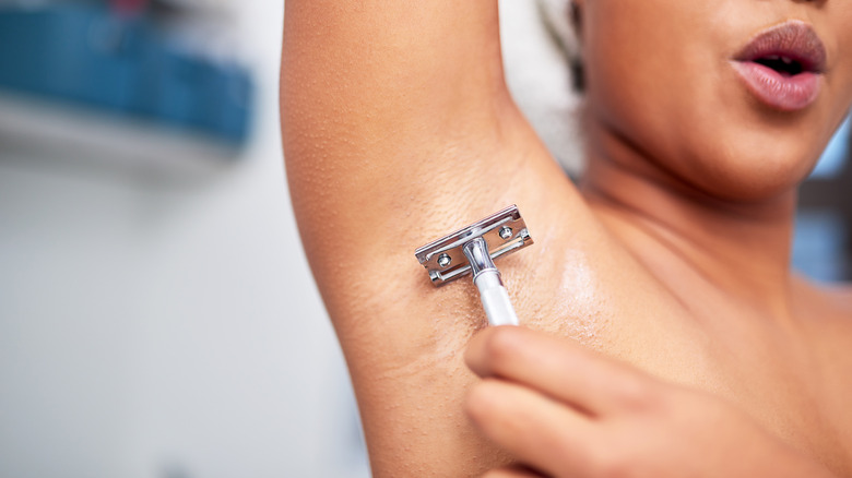 woman shaving her armpit