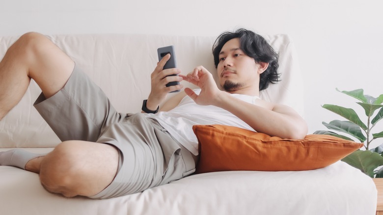 Asian man relaxing on sofa