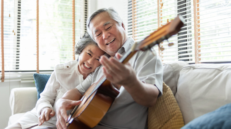 Man playing guitar woman smiling