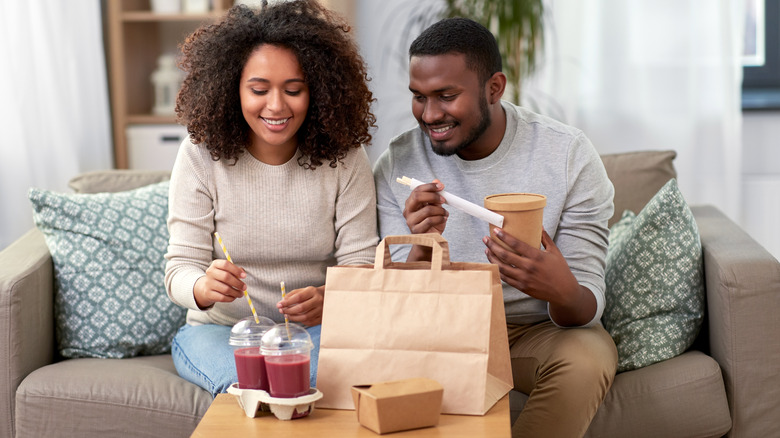 man and woman eating take out