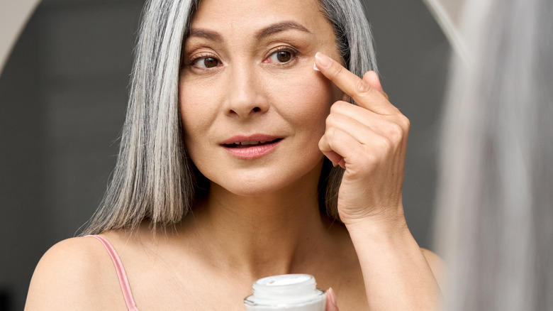 woman putting on eye cream