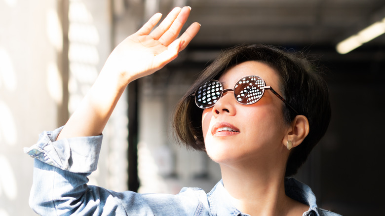 Model in sunglasses blocking sunlight