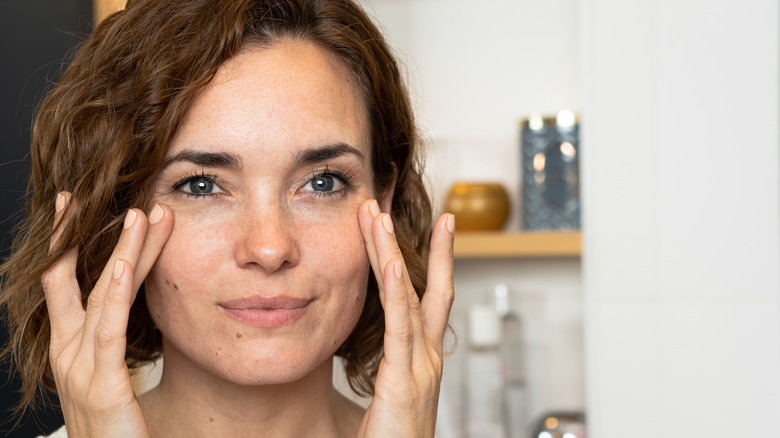 Woman applying exfoliant to skin