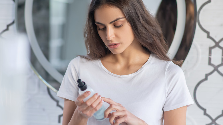 Woman reading beauty product label