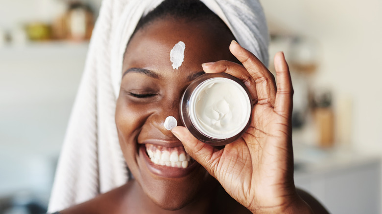 Woman putting moisturizer on skin