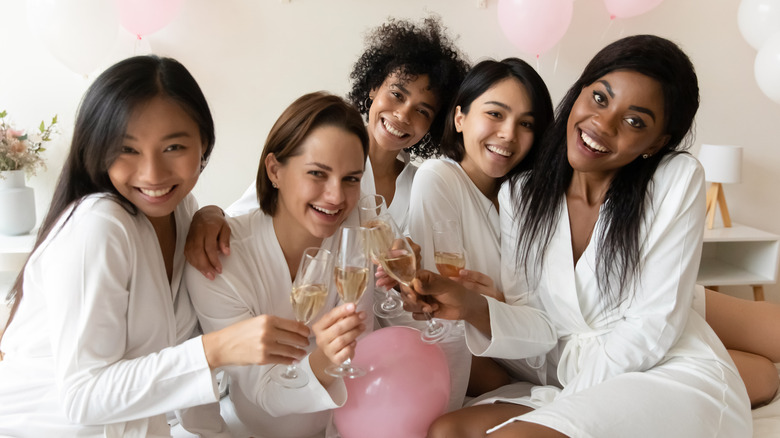 Women in robes clinking glasses