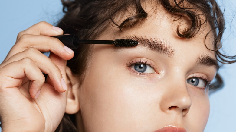 Woman combing brows for texture