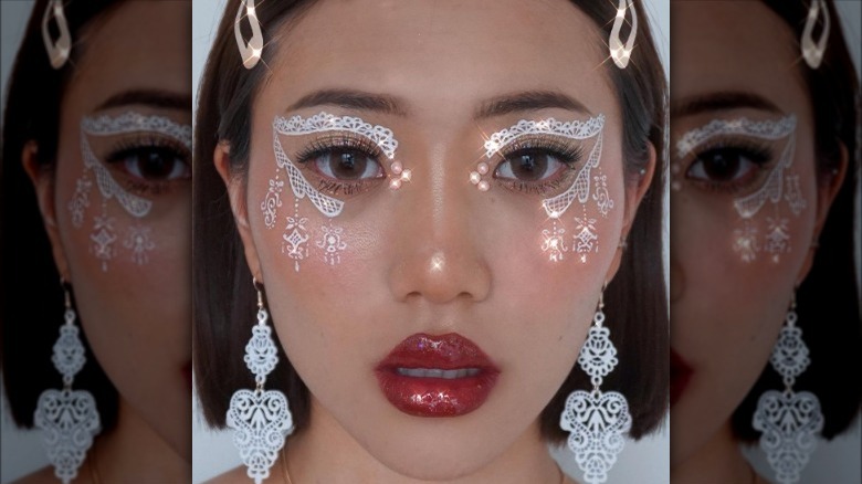 A woman with white lace design makeup