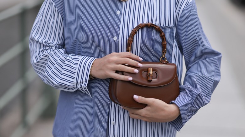 woman with dark bamboo handbag