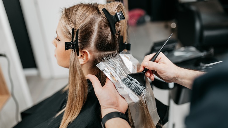 Stylist applying bleach to hair