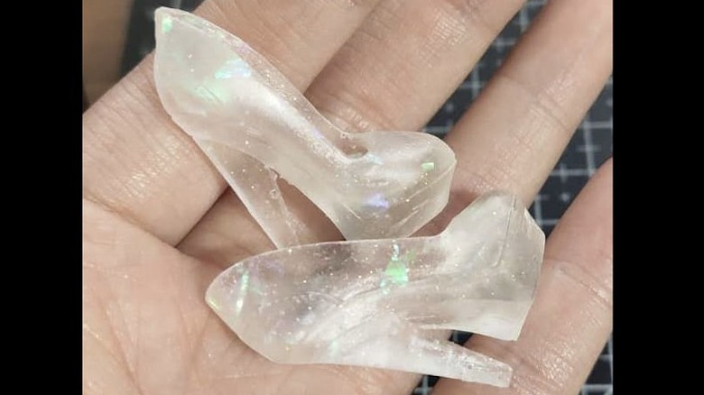 Instagram user @paperark_chn holding miniature clear doll heels in hand