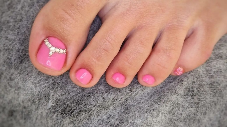 Person with rhinestone pink pedicure