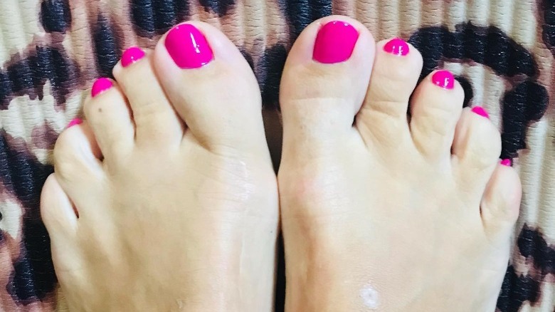 Person showing off vibrant pink pedicure