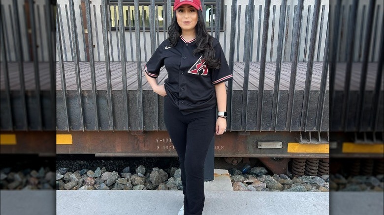 Woman wearing a baseball jersey with black pants