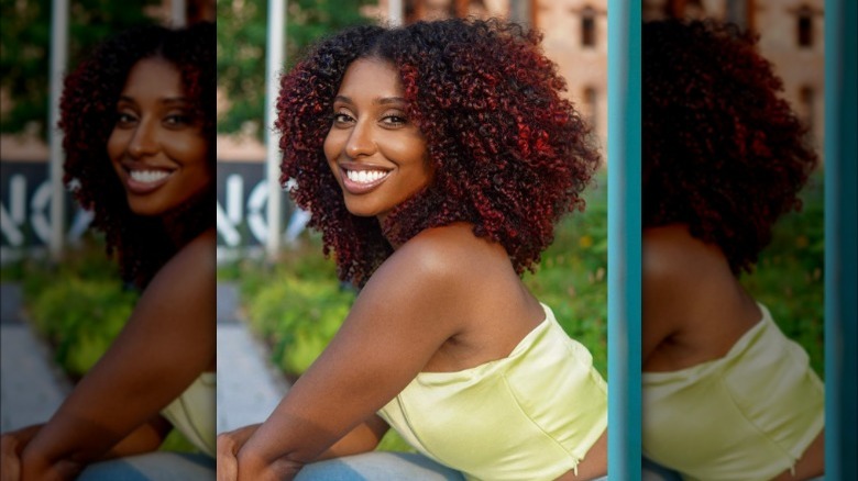 A woman with red highlights on curly hair