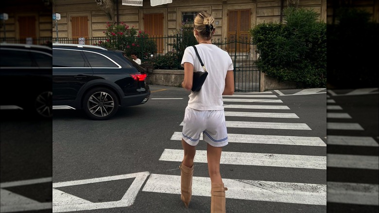 Woman wearing basketball shorts, tan boots