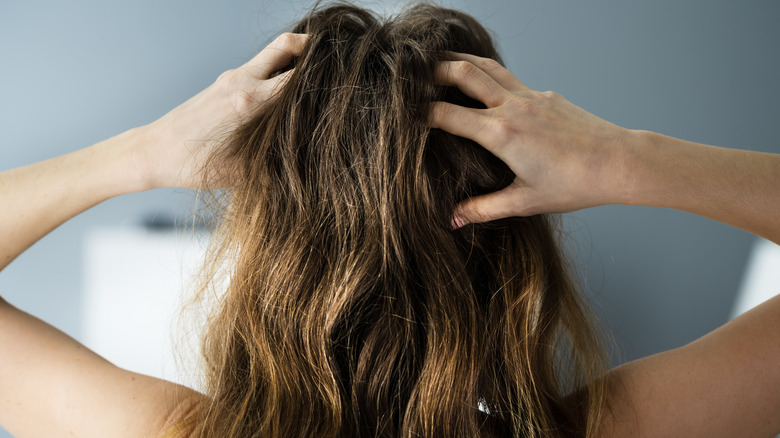 Rear view of woman massaging her head