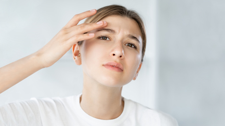 A woman examining her face