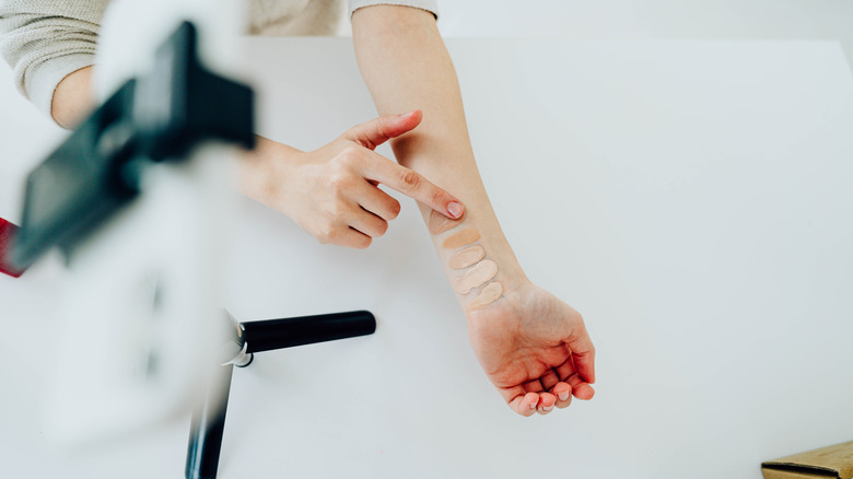 A woman swatching shades on her arm