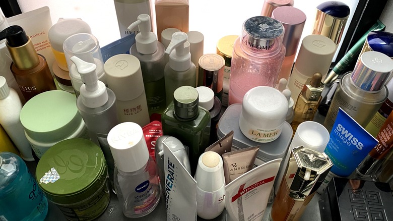 A large collection of half-used skincare products.