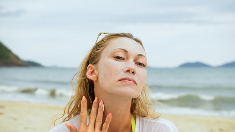 Woman at beach putting sunscreen on