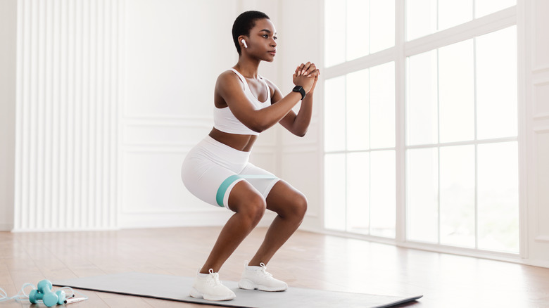 woman doing squats on mat