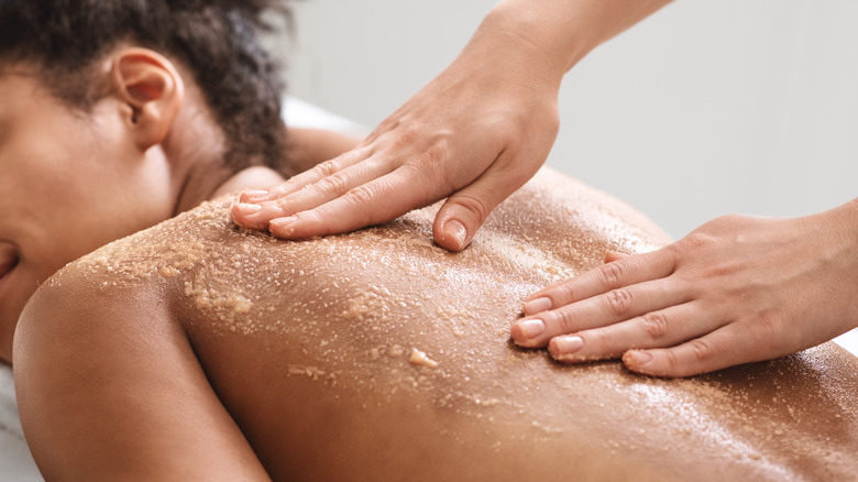 woman getting a body scrub treatment 