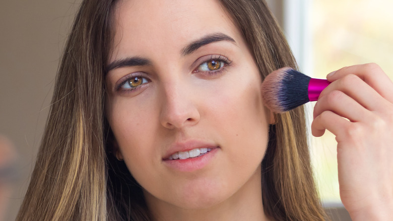 Woman applying bronzer