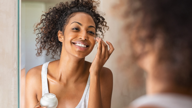 Woman applying moisturizer