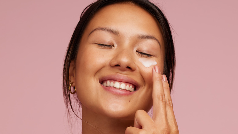 woman moisturizing face