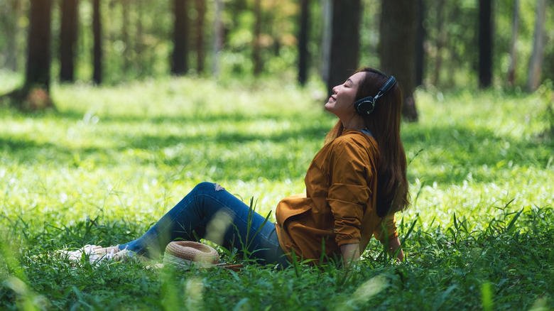 Woman listening to music in grass