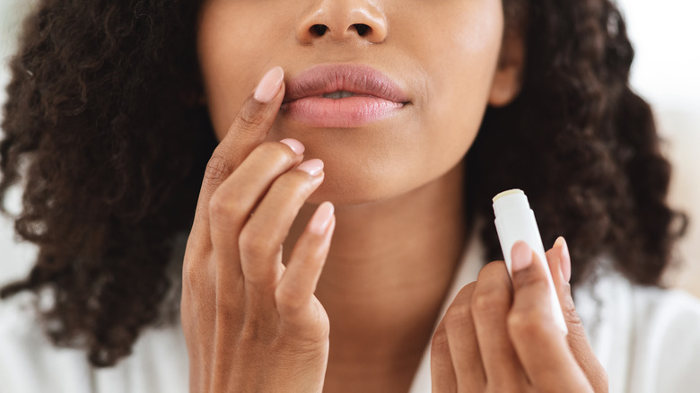 Woman putting on chapstick