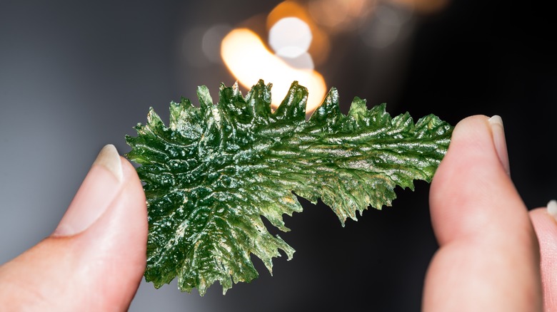 person holding moldavite