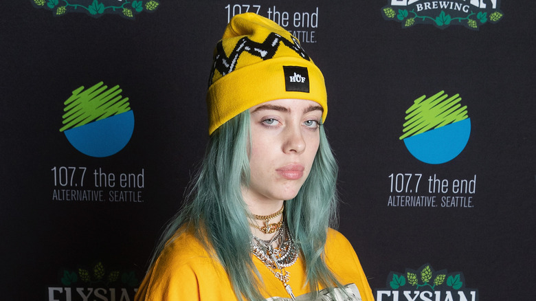 Billie Eilish yellow hat teal hair