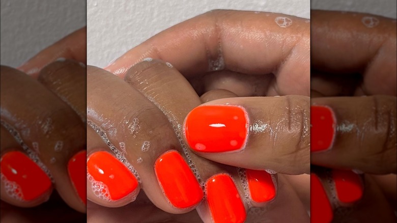 Woman witth bllood orange short nails