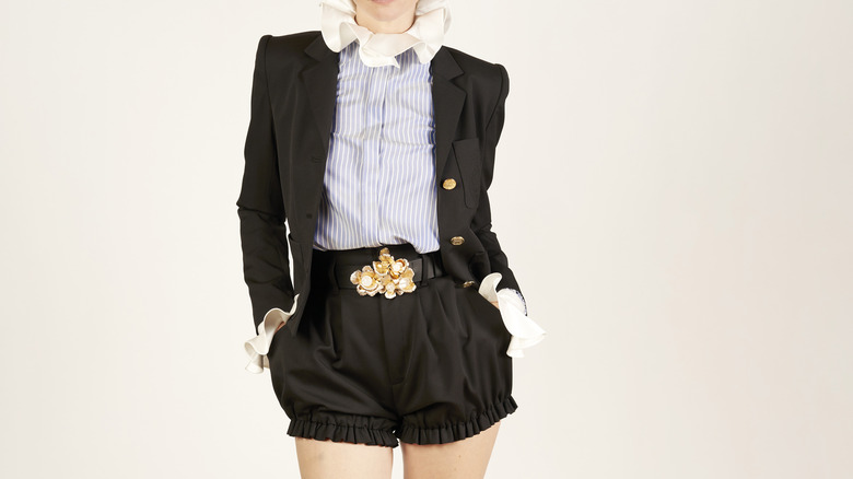 woman wearing black bloomers blazer ruffled collar