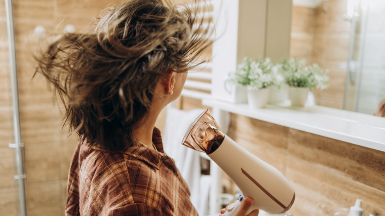 Woman using blow dryer