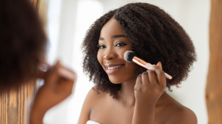 woman applying powder blush 